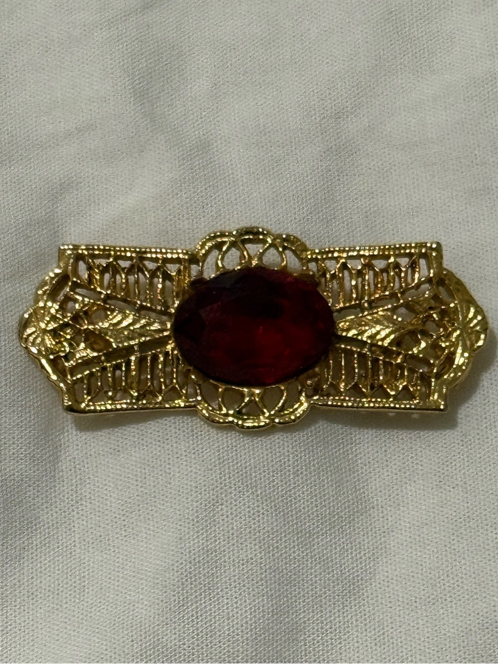 Gold Tone Filigree Brooch with Deep Red Oval Stone